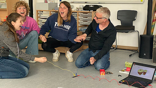 Referendar:innen bilden mit Händen einen Stromkreis